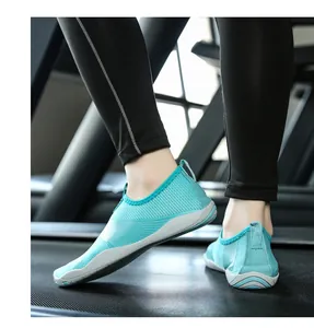 Dettaglio delle scarpe da acqua turchesi traspiranti in uso su un tapis roulant professionale.