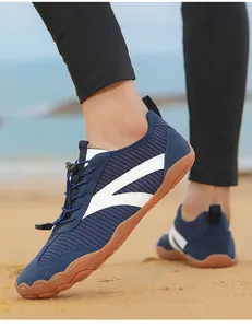 Primer plano detallado de zapatos de agua descalzos azules en la arena con cordones rápidos.