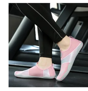 Dettaglio delle scarpe da scoglio rosa traspiranti su un tapis roulant da palestra