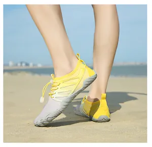 Detailed side view of breathable quick-dry yellow water shoes worn on a sandy beach.