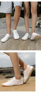 Detailed view of white quick-dry five-finger water shoes on a sandy beach outdoor terrain