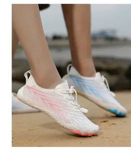 Close-up of white breathable wading shoes with pink arrow pattern on beach sand.