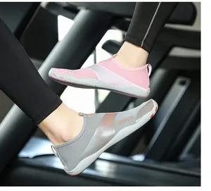 Primo piano di scarpe da scoglio traspiranti ad asciugatura rapida rosa e grigie per lo sport.