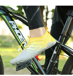 Close-up of yellow breathable barefoot water shoes on a bicycle pedal in nature.
