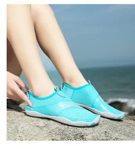 Vista macro dettagliata di scarpe da scoglio blu traspiranti su uno sfondo di spiaggia