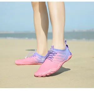 Detail of pink and purple breathable quick-dry five-finger water shoes on beach