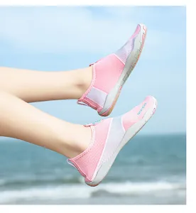 Scarpe da scoglio rosa traspiranti ad asciugatura rapida su sfondo di spiaggia soleggiata