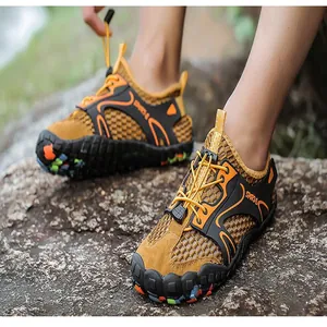 Detailed view of breathable mesh outdoor wading shoes with rugged outsole on rocky terrain