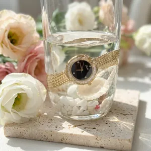 Close-up of Scottie gold waterproof quartz watch with diamond-set bezel in water