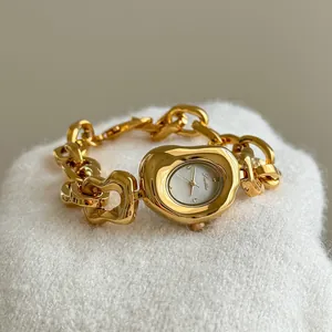 Detail showing the intricate gold-tone chain and irregular oval dial of Scottie watch