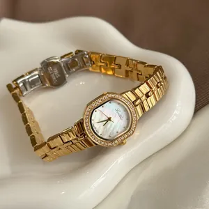 Primer plano del reloj de cuarzo Scottie dorado con esfera de nácar y piedras