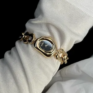 Detailed view of Scottie irregular gold chain fashion watch with black dial on mesh sleeve