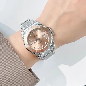 Close-up of Scottie quartz watch with rose gold dial and rotating bezel on a wrist.