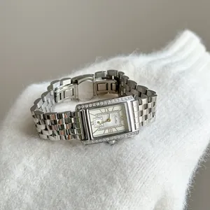 Close-up of Scottie vintage silver watch with diamond-set bezel on white knitwear