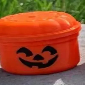 Nahaufnahme des lächelnden Gesichts auf einer Mini-Halloween-Kürbis-Geschenkbox.