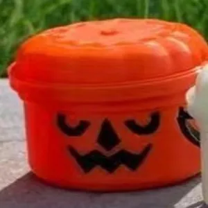 Detailansicht einer kleinen orangefarbenen Halloween Kürbis Süßigkeitendose mit Deckel
