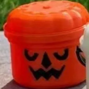 Miniature orange plastic Halloween pumpkin candy bucket with lid for festive gifting