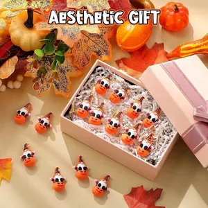 Vista de detalle de figuras de gnomos de Halloween en una caja de regalo con hojas secas