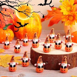 Múltiples figuras en miniatura de gnomos de Halloween con bases de calabaza sobre madera