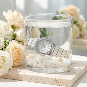 Detailed view of silver Scottie watch inside a water glass showing water resistance