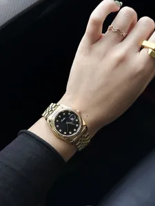 Close-up of gold Scottie ladies quartz watch with black dial and stone markers