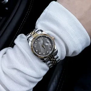 Close-up detail of luxury women's two-tone quartz watch with crystal hour markers
