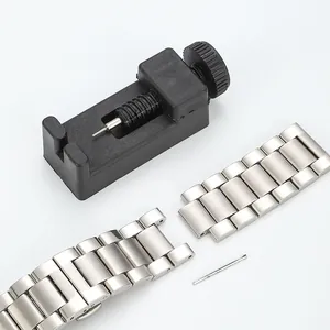 Detail eines schwarzen Uhrenarmband-Kürzers mit Edelstahlarmband und Stift