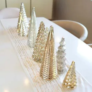 Elegant gold and silver glass Christmas tree ornaments displayed on a white table runner