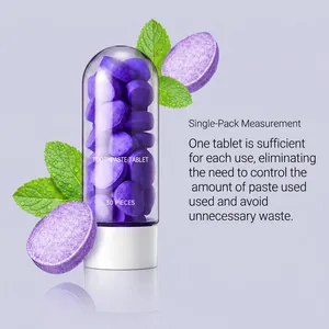 Gros plan de comprimés de dentifrice à la menthe violette dans un flacon capsule.