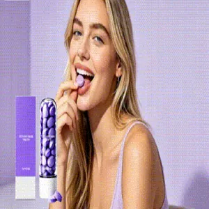 Jeune femme tenant une tablette de dentifrice violet pour un nettoyage doux des dents