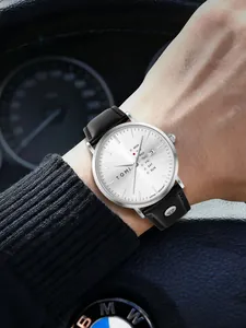 Nahaufnahme der minimalistischen TOMI Herren Quarzuhr mit schwarzem Lederarmband am Handgelenk.