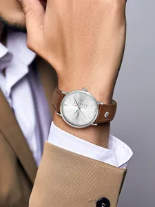 Nahaufnahme der minimalistischen TOMI Herrenquarzuhr mit braunem Lederarmband am Handgelenk