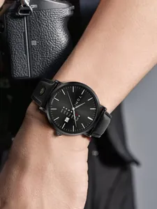 TOMI minimalistische schwarze Herren-Quarzuhr mit Datumsanzeige am Handgelenk getragen