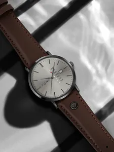 Nahaufnahme der minimalistischen TOMI Quarzuhr mit braunem Lederband und grauem Blatt