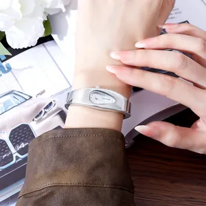 Nahaufnahme einer silbernen Y2K-Armbanduhr im Wassertropfen-Stil am Handgelenk getragen.