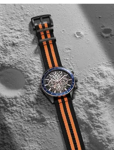 Close-up of Megir men's sports watch with orange nylon strap on grey lunar texture