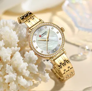 Primer plano del reloj CURREN dorado para mujer con esfera de nácar y cristales