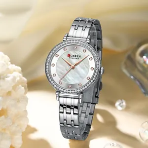 Primer plano del reloj plateado para mujer CURREN con esfera de nácar y bisel de diamantes