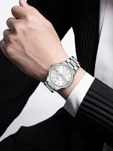 Close-up of a silver TOMI men's quartz watch with diamond dial on a professional wrist