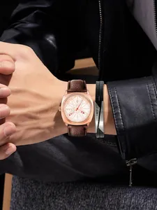 Primer plano del reloj de cuarzo vintage TOMI y la pulsera de cuero en la muñeca.