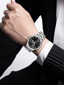 Close-up of TOMI business quartz watch on man's wrist, black dial with silver band