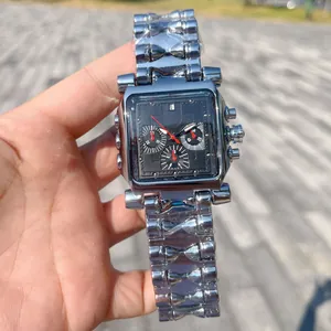 Gros plan d'une montre à quartz carrée pour homme avec un bracelet à maillons argentés.