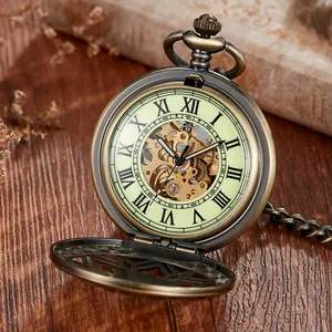 Gros plan d'une montre de poche mécanique vintage en bronze avec cadran lumineux et squelette