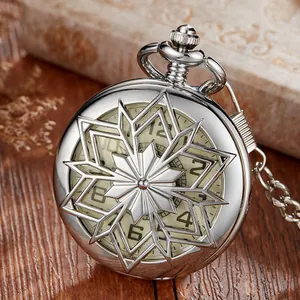Gros plan d'une montre de poche mécanique vintage en argent avec motif de flocon ajouré.