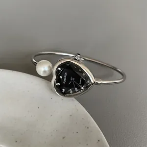 Close-up detail of a silver heart-shaped SUNLIFEX bracelet watch with pearl accent