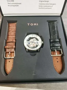 Detailansicht des TOMI Skelettuhr-Geschenksets mit schwarzen und braunen Lederbändern.