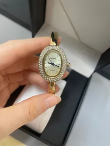 Nahaufnahme der SUNLIFEX Damenarmbanduhr in Ovalform mit Strasssteinen und Goldfinish