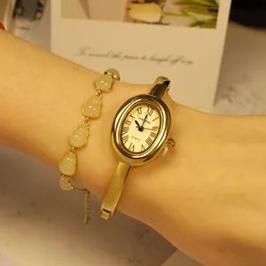 Detail einer ovalen SUNLIFEX Goldarmbanduhr für Damen mit passendem Steinarmband am Handgelenk.