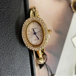 Elegante ovale goldene Armbanduhr SUNLIFEX für Damen mit glitzernder Kristalllünette.