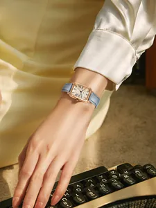 Gros plan élégant d'une montre carrée vintage avec bracelet en cuir bleu au poignet